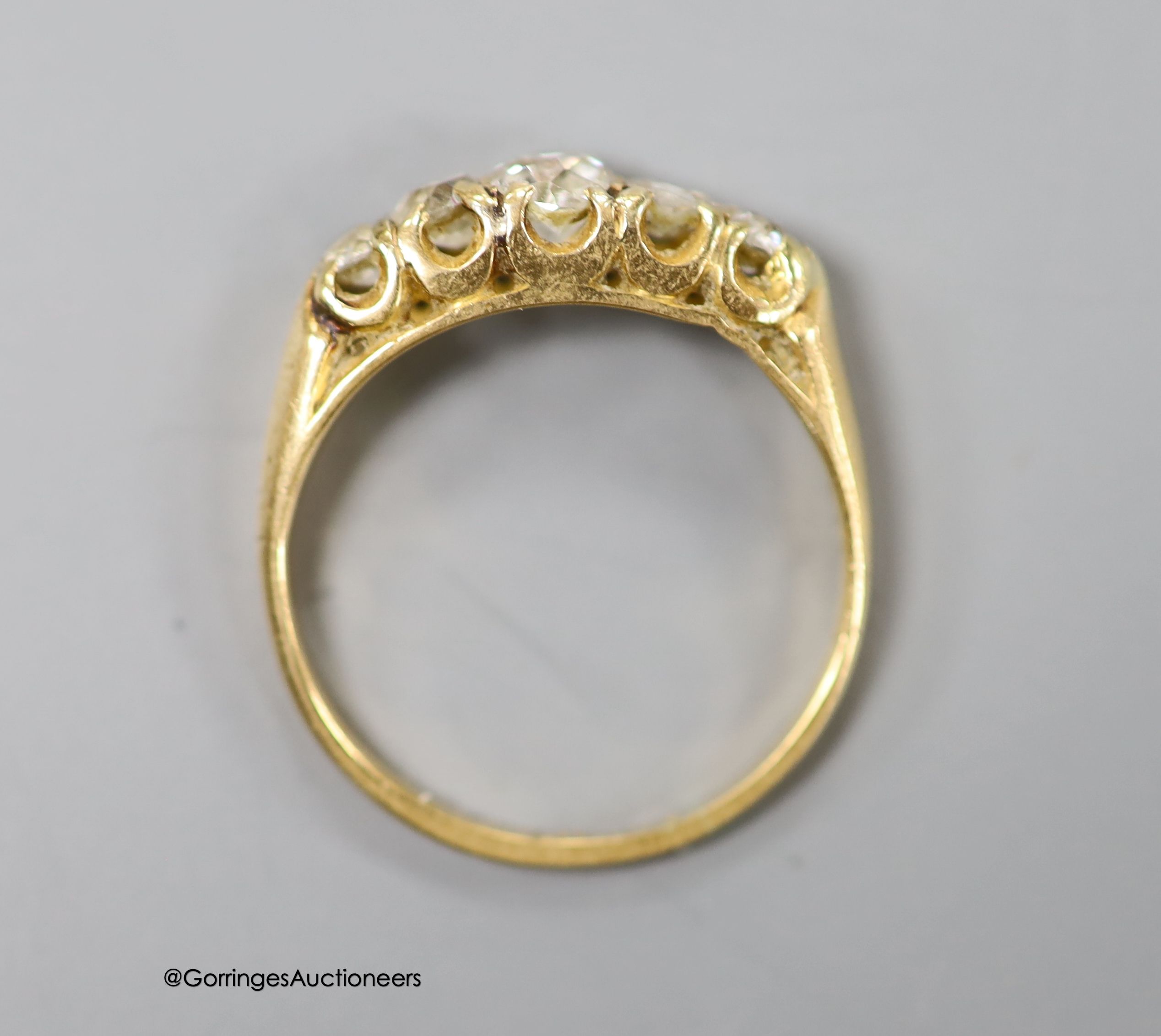 An 18ct and graduated five stone diamond set half hoop ring, size L, gross 2.6 grams.